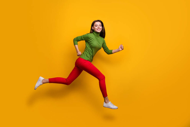 Full size photo of positive cheerful girl jump run fast after black friday sales wear casual style clothes white sneakers isolated over vibrant color background - Fotoğraf, Görsel