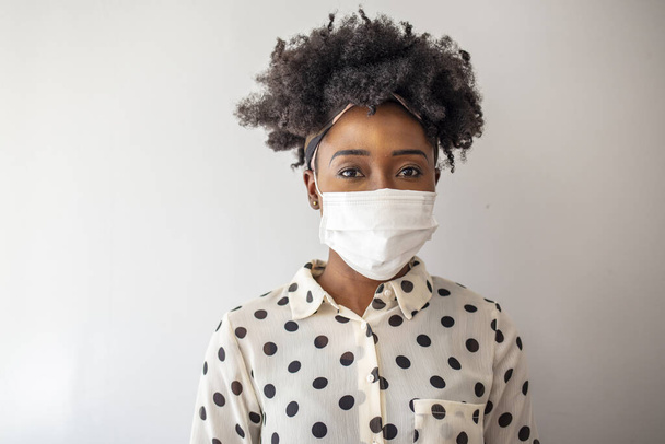 Masked woman - protection against influenza virus. African - American woman wearing mask for protect. Woman wear with protective face mask at home. Stop the virus and epidemic diseases. - Fotografie, Obrázek