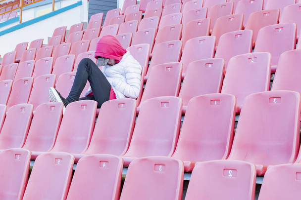 A young girl on the podium of an empty stadium - Φωτογραφία, εικόνα