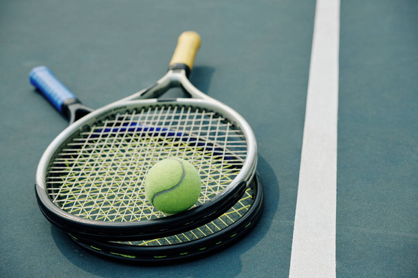 Two tennis rackets and ball on outdoor court, selective focus - Fotoğraf, Görsel