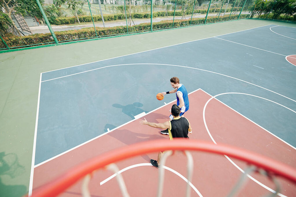 Studenti universitari che giocano a basket sul campo all'aperto - Foto, immagini