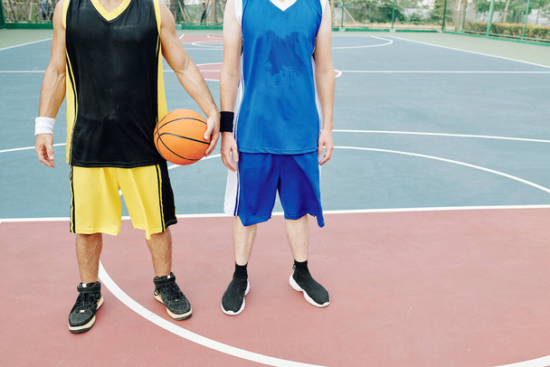 屋外コートでバスケットボールをした後に疲れた汗びっしょりの若いスポーツマン - 写真・画像