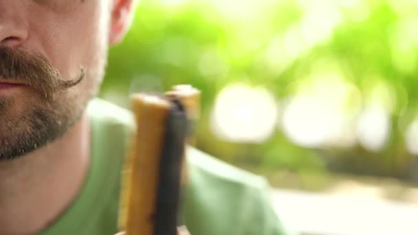 Ein bärtiger Mann mit zusammengerolltem Schnurrbart isst in einem Café Schokolade. Halbe Gesichter im Rahmen mit Copyspace - Filmmaterial, Video