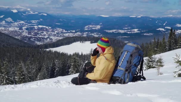 Tourist talks on the phone in the mountains in winter - Footage, Video