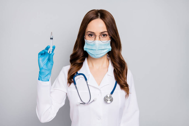 Close-up portrait of her she nice attractive experienced wavy-haired doc surgeon phonendoscope stethoscope making prick procedure isolated over grey pastel color background - Foto, Imagem