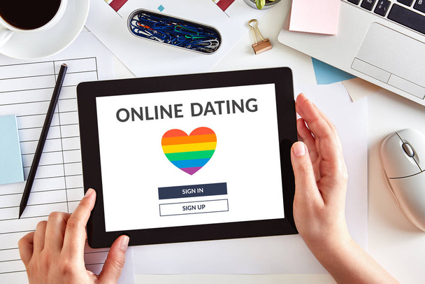 Eller, iş masasının üzerinde LGBT flört uygulaması konsepti olan dijital tablet bir bilgisayar kullanıyor. Eşcinsel online randevu. Üst görünüm - Fotoğraf, Görsel