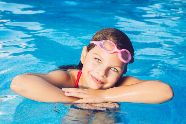 Portrait of a small smiling girl in a garden swimming pool - Foto, Imagen