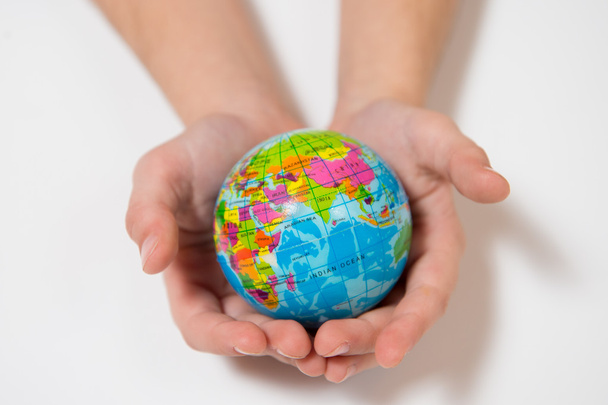 Niña sosteniendo el pequeño globo mundial en sus manos
 - Foto, Imagen