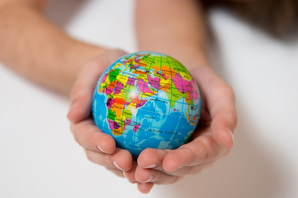 Miúdo segurando pequeno globo mundial em suas mãos
 - Foto, Imagem