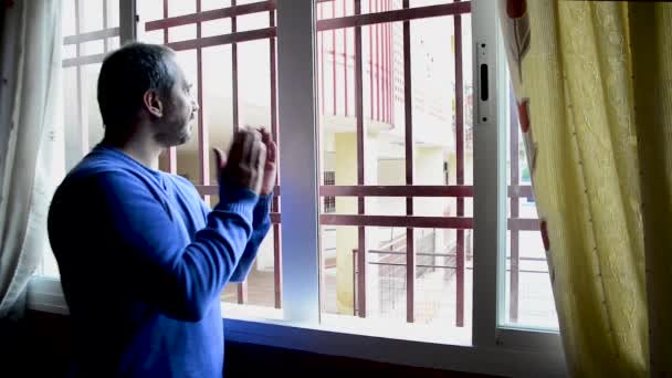 Człowiek klaskający w oknie dla koronawirusa - Materiał filmowy, wideo