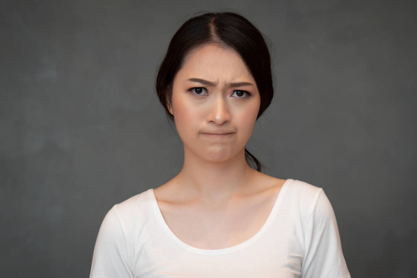 portret twarzy smutnej nieszczęśliwej dziewczyny; portret zdenerwowanej sfrustrowanej chińskiej lub wschodniej Azji; młoda dorosła chińska modelka azjatycka - Zdjęcie, obraz