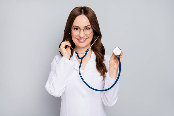 Portrait of her she nice attractive cheerful confident wavy-haired doc examining client patient diagnostic center clinic listening heart beat isolated over grey pastel color background - Foto, Bild
