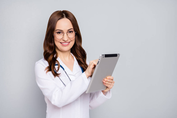 Photo of professional beautiful family doc lady hold modern technology tablet e-book online consultation quarantine wear specs stethoscope white lab coat isolated grey color background - Φωτογραφία, εικόνα