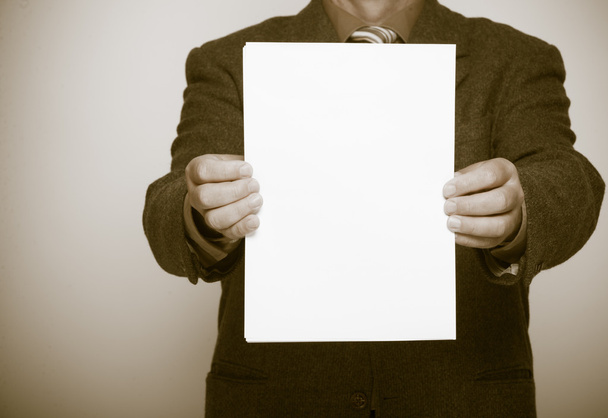 Businessman holding blank sheet of paper. Business concept. - Foto, afbeelding