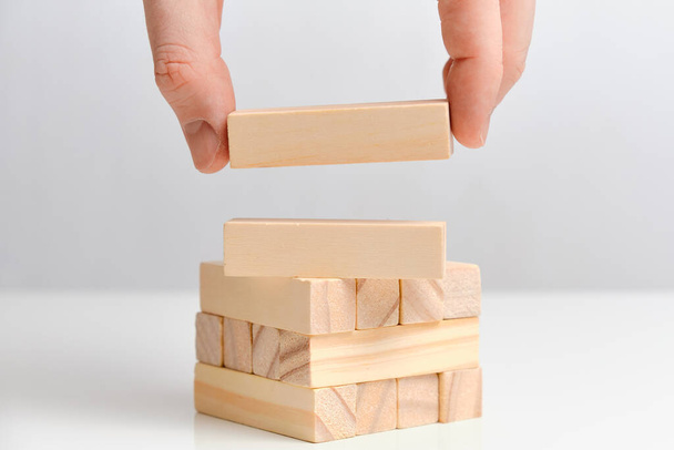 La mano sostiene dos bloques de madera sobre un fondo blanco. Copiar espacio. De cerca.
. - Foto, imagen