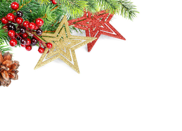 Weihnachtskomposition mit Sternen? Rote Stechpalmenbeeren und grüne Tannenzweige isoliert auf weißem Hintergrund - Foto, Bild