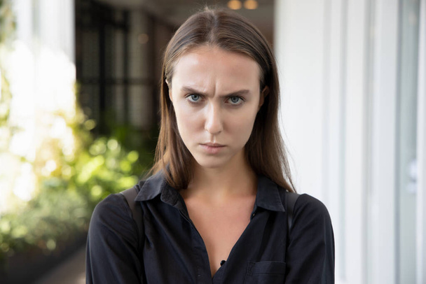 portret twarzy nieszczęśliwej wściekłej zdenerwowanej kobiety; portret negatywnej wściekłej niezadowolonej sfrustrowanej białej kobiety rasy kaukaskiej; młoda dorosła rosyjska modelka rasy kaukaskiej - Zdjęcie, obraz