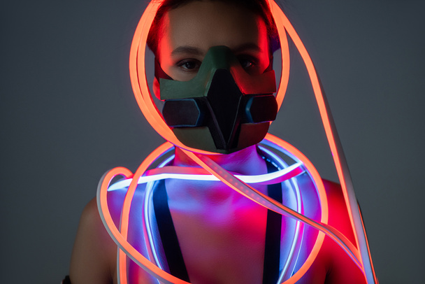 futuristica donna afroamericana in respiratore e illuminazione al neon
 - Foto, immagini