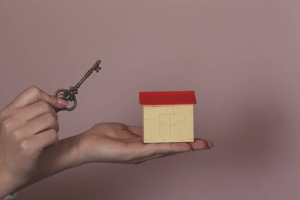 woman hand wooden house model with key - Фото, зображення