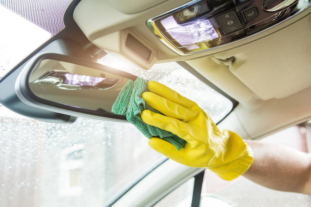 Cleaning service. Man in uniform and yellow gloves washes a car interior in a car wash - Fotoğraf, Görsel