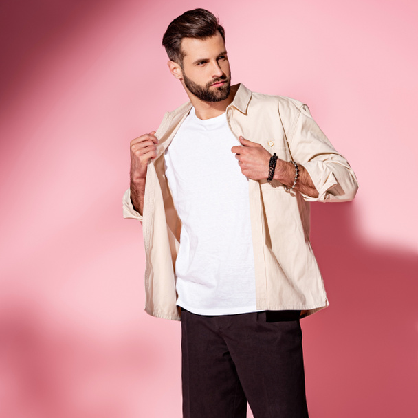 fashionable bearded young man posing in summer shirt and shorts on pink - Foto, Imagen