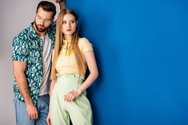 fashionable young couple posing in summer clothes on grey and blue  - Foto, Imagen