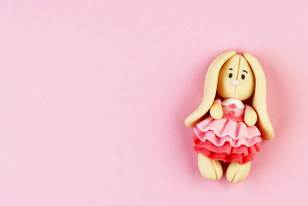 Plasticine Easter Bunny on a pink background. cute Bunny in a beautiful dress - Valokuva, kuva