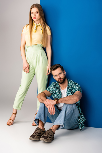 beautiful fashionable couple posing in summer clothes on grey and blue  - Fotografie, Obrázek