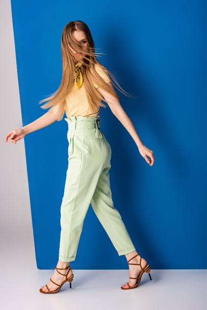 bela menina da moda posando em calças de verão verdes e sandálias de salto em cinza e azul
 - Foto, Imagem