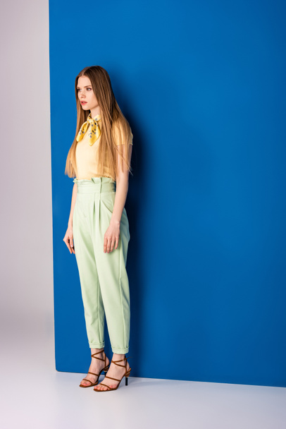 stylish girl posing in green summer trousers and heeled sandals on grey and blue - Valokuva, kuva