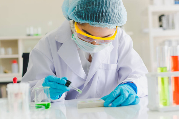 Azjatyccy naukowcy przygotowują chemikalia do badań i analiz w laboratorium. Naukowcy wyczyścić okulary i białe koszule. Koncepcja nauki i chemii - Zdjęcie, obraz