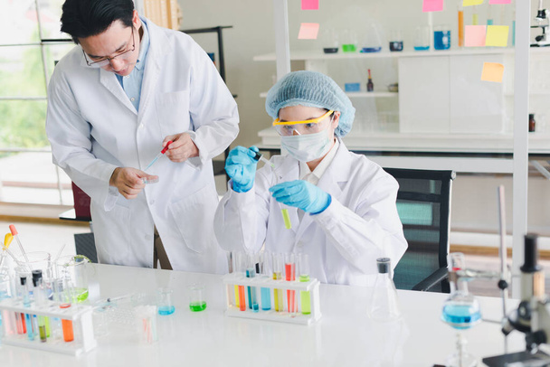 Scientifiques asiatiques, les hommes et les femmes aident à tester et analyser diverses substances chimiques de couleur dans les laboratoires qui ont de nombreux équipements scientifiques
. - Photo, image