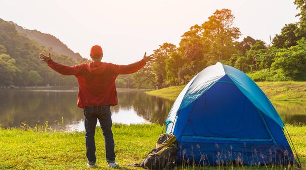 自然の中でテントと若いアジアの旅行者の男のキャンプ。バックパッカー,リラックス,休日,アクティビティ,コピースペースとハイキングのコンセプト. - 写真・画像