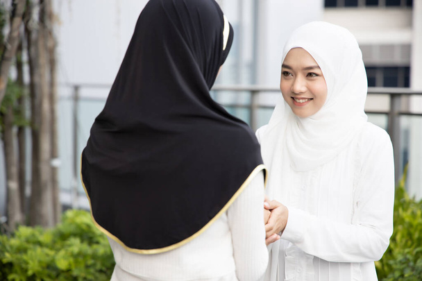 Мусульманская женщина приветствие с рукопожатием; Концепция исламского приветствия женщины, религия мира, Рамадан, Салам, Ас-саламу алейкум, Мир вам; Азиатская мусульманская молодая женщина модель
 - Фото, изображение