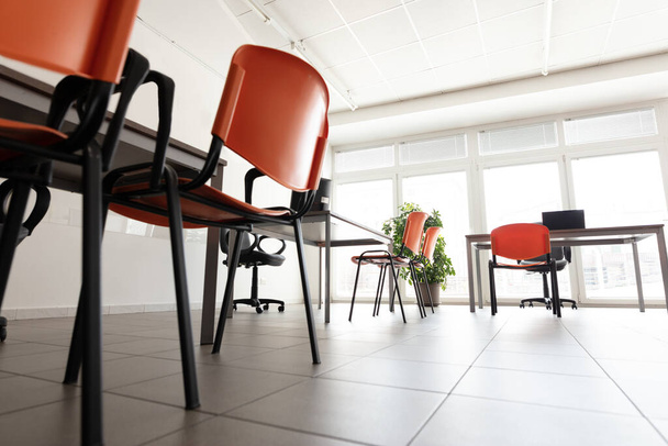 Nízký úhel jasné kancelářské místnosti bez lidí během pandemie viru korony. - Fotografie, Obrázek