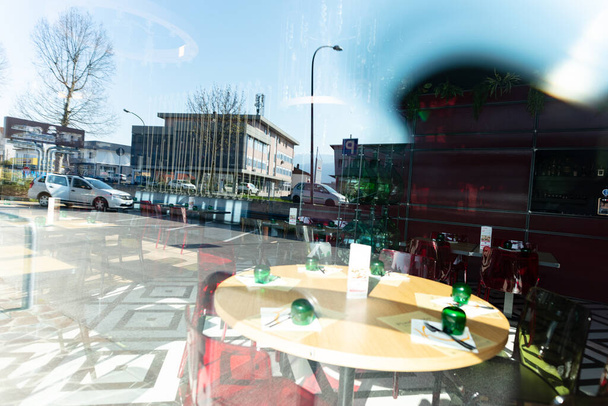 Ein geschlossenes, leeres Restaurant und ein Spiegelbild der Stadtstraße. - Foto, Bild