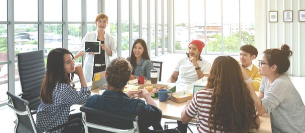 Junge multiethnisch vielfältige kreative asiatische Gruppe im Gespräch oder Brainstorming in Büro-Meeting-Workshop mit Technologie. Glückliche junge Studentin oder College-Marketing-Team verbringen Kaffeepause Zeit miteinander. - Foto, Bild