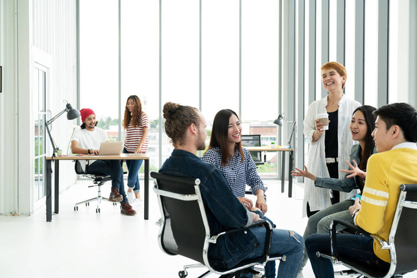 Група багаторасової молодої творчої команди розмовляє, сміється та мозковий штурм на зустрічі в сучасному офісі
  - Фото, зображення