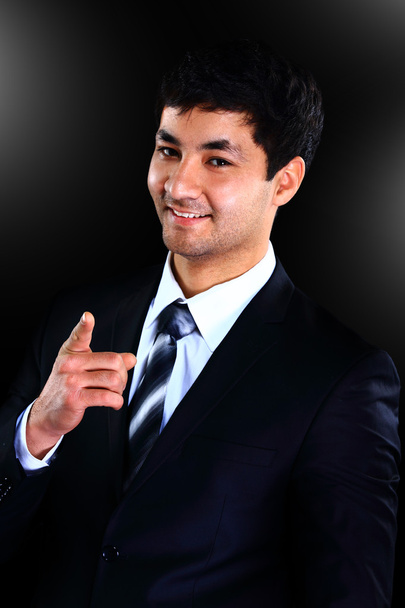 Vertical portrait of a happy young businessman over a black background - Fotó, kép