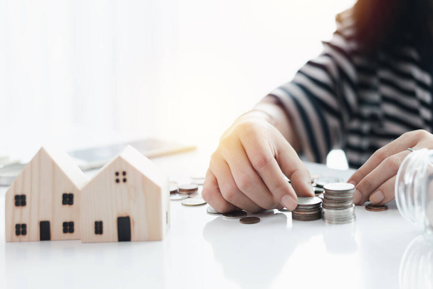 Kobieca ręka oszczędzająca monetę na planowanie, mieszkalnictwo i koncepcję finansową nieruchomości - Zdjęcie, obraz