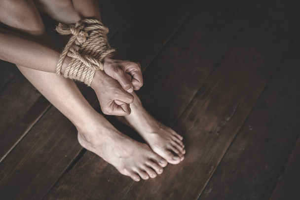 A woman's hand tied with a rope,  Detainee was detain and hidden by human traffickers, Woman bondage, stop violence against Women, international women's day - 写真・画像