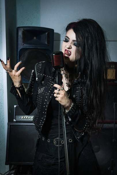 Estrella de rock cantando en un micrófono en el estudio de grabación
 - Foto, imagen