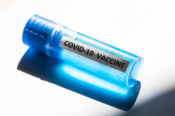 Conceptual image of a recipient containing a vaccine for coronavirus COVID-19, in a lab. - 写真・画像