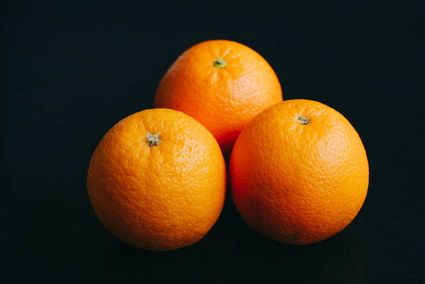  horizontal poster photo of an orange on a black background with light coming - Photo, Image