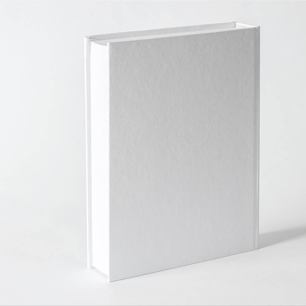 Mockup of closed blank square book at white textured paper background. Blank square cover book template on white background - Fotografie, Obrázek