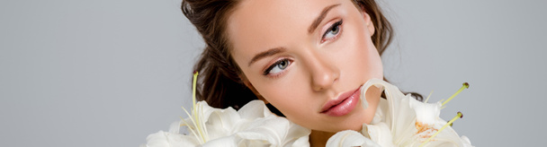 panoramic shot of attractive woman near white blooming flowers isolated on grey  - Photo, Image