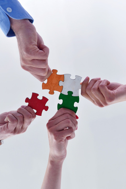 Group of business people assembling jigsaw puzzle - 写真・画像
