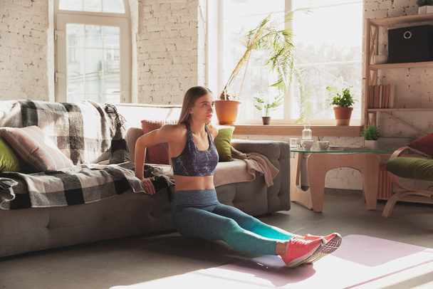 Młoda kobieta uczy w domu kursy online fitness, aerobik, sportowy styl życia podczas kwarantanny - Zdjęcie, obraz
