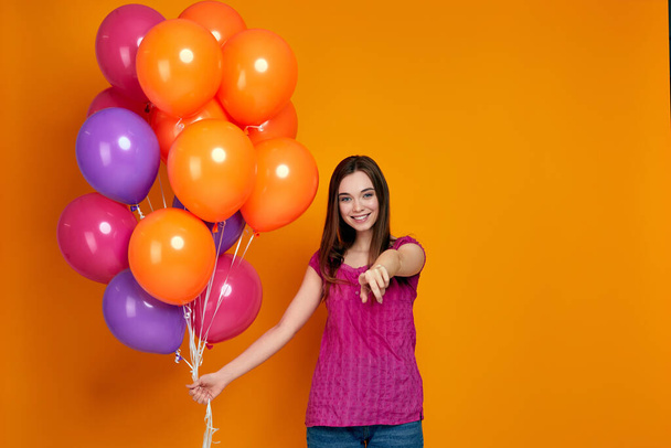 S girl in pink t-shirt posing with bright colorful air balloons - Zdjęcie, obraz