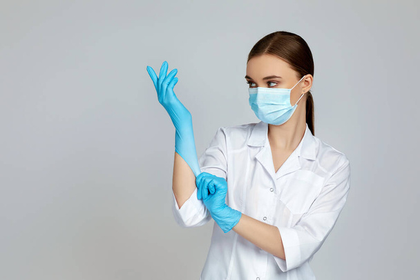 doctor in white uniform wearing mask and rubber gloves - Φωτογραφία, εικόνα
